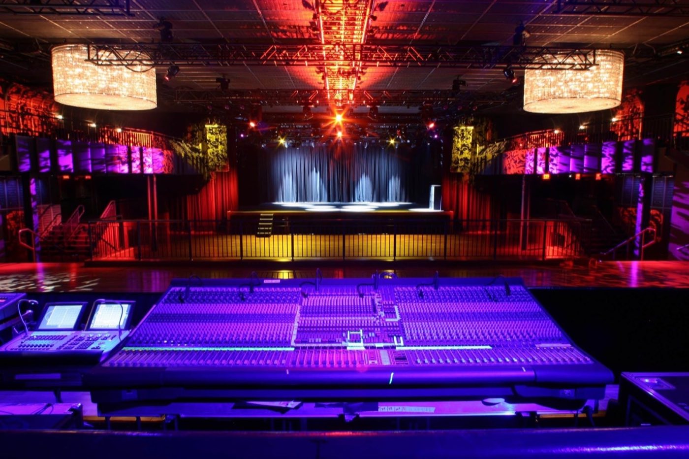 Main floor with stage, lighting rig and mixing console in the foreground