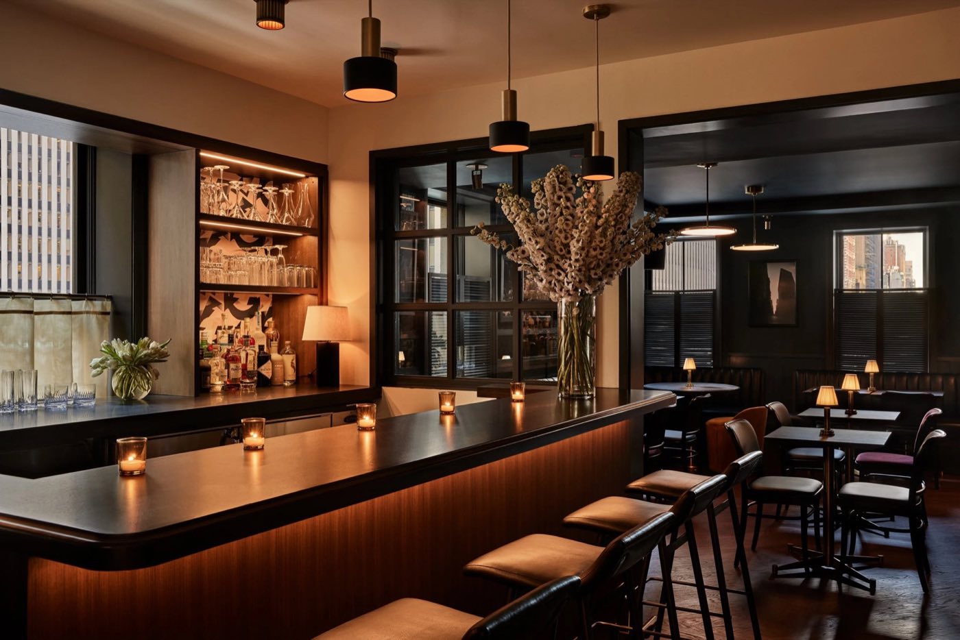 Third-floor dining room with a long bar, pendant lights and banquette tables