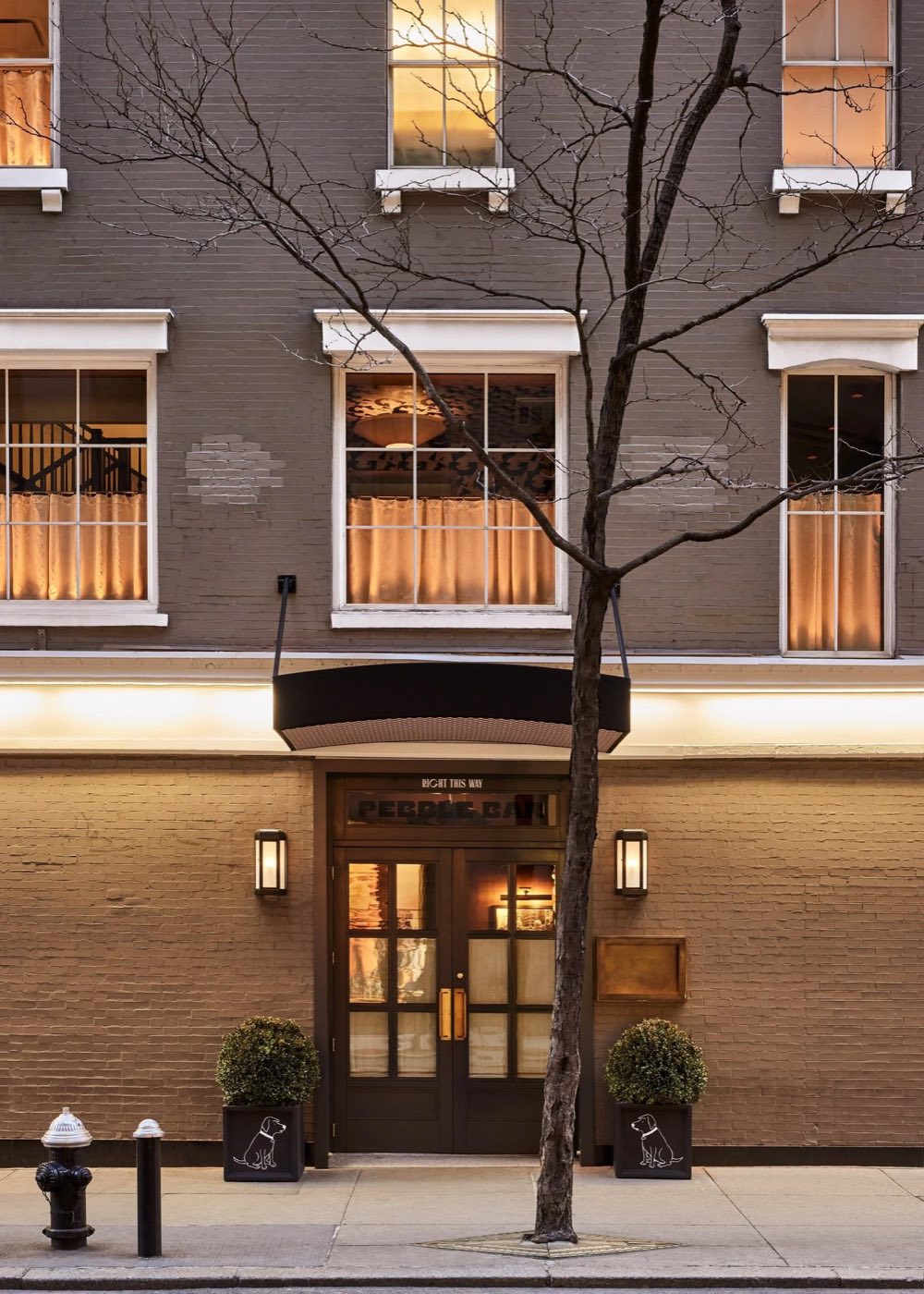Brick townhouse facade on West 49th Street with a canopy entrance