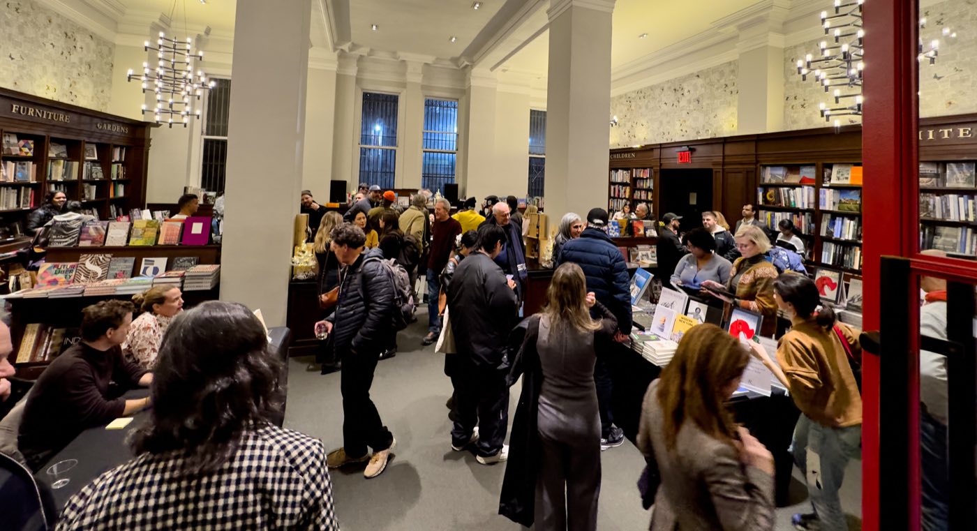 Evening event crowd in the Salon under chandeliers and white columns