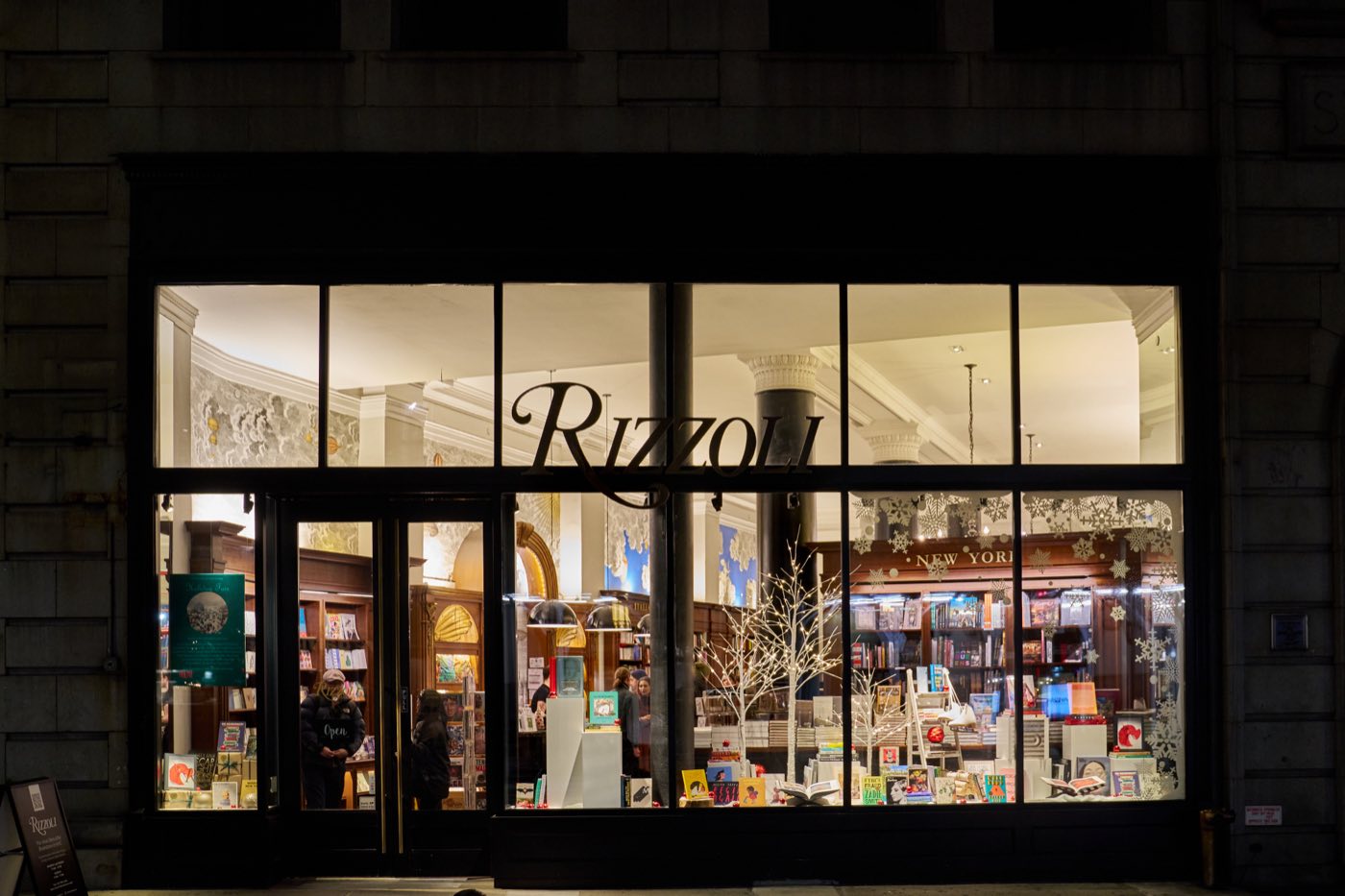 Glass storefront on Broadway lit from inside at night