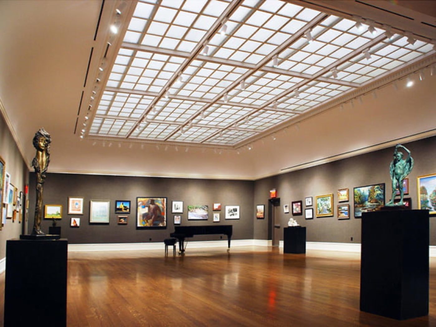 Skylight Gallery with a coffered glass ceiling, wood floors and paintings on the walls