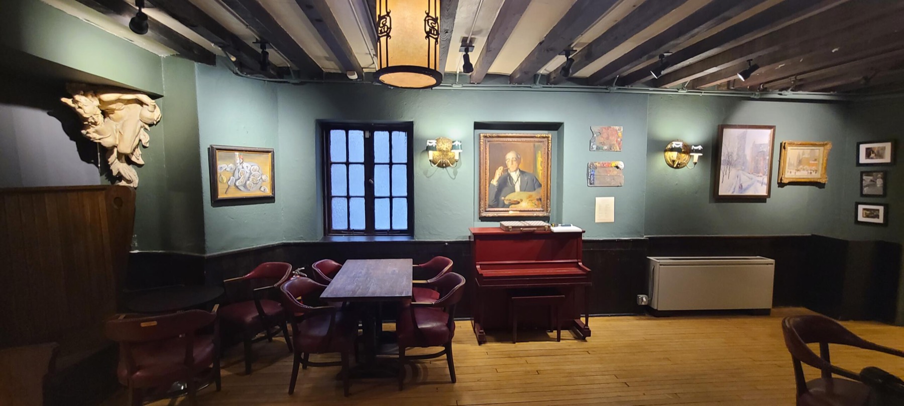 Wiggins Bar with beamed ceiling, dark wood and framed paintings