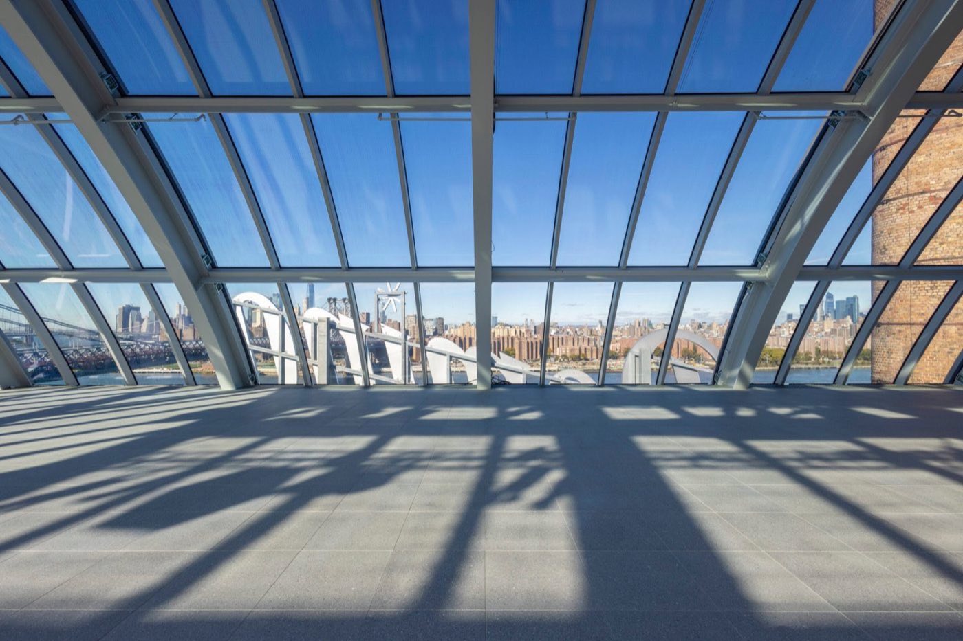 Wide view across the empty dome floor toward the Manhattan skyline