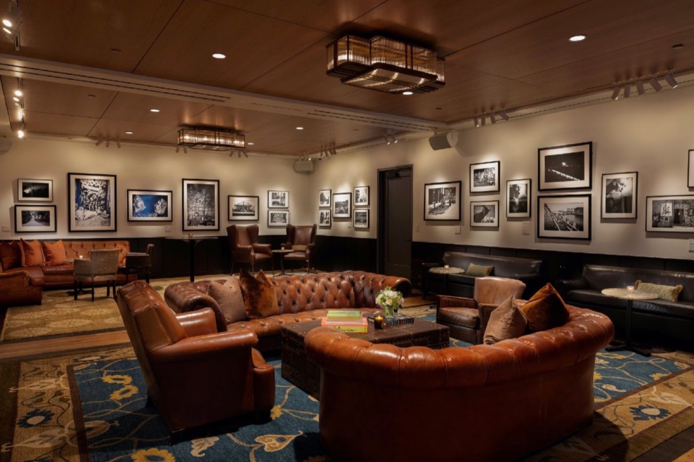 The Gallery set as a lounge with leather sofas and armchairs under framed art