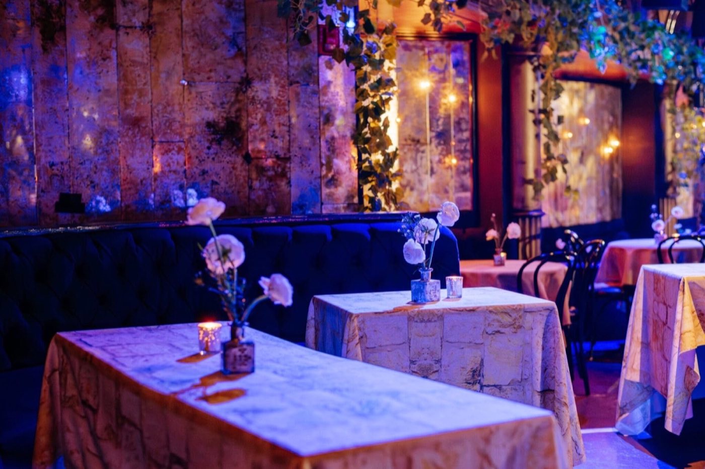 Dining tables with patterned linens and candles set in the hall's lounge area