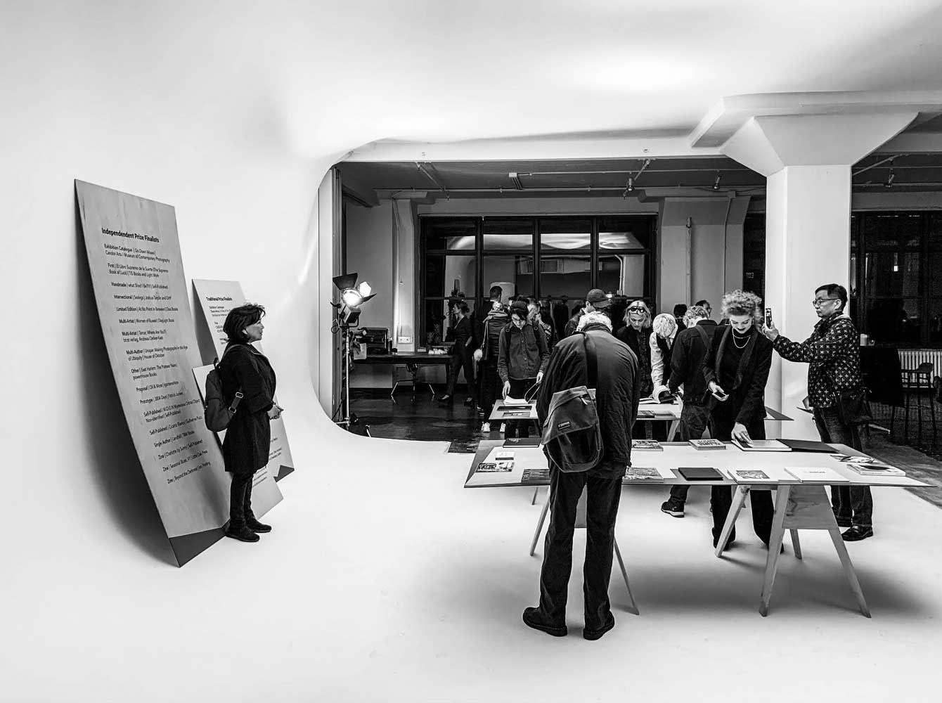Black and white view of guests at an exhibition inside a studio