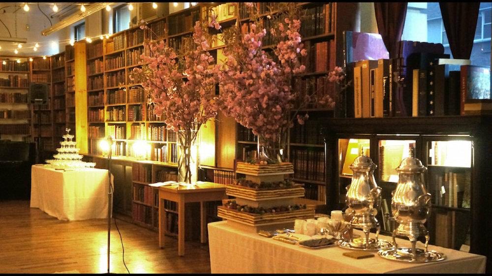 Rare Book Room set for a reception with flowering branches, dessert tables and bookcases