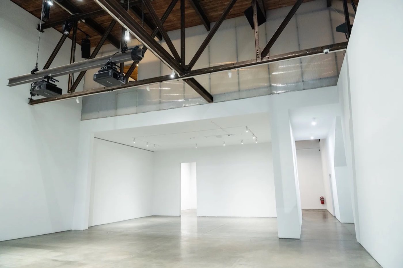 Main studio with rigged projectors on steel trusses and a mezzanine level above