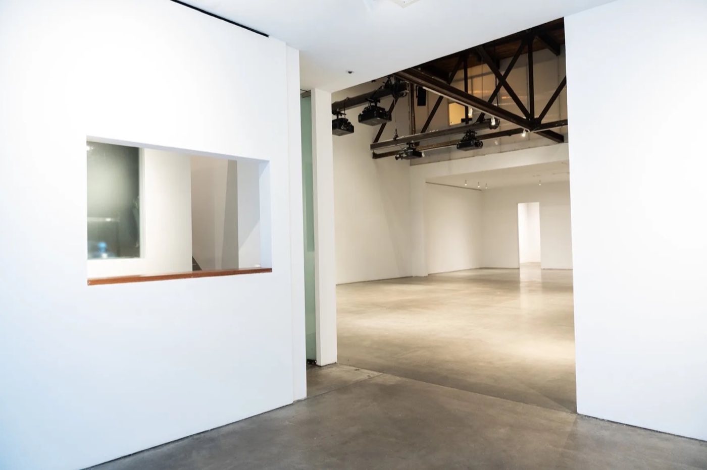 View from the entry into the open white gallery floor with a lighting grid