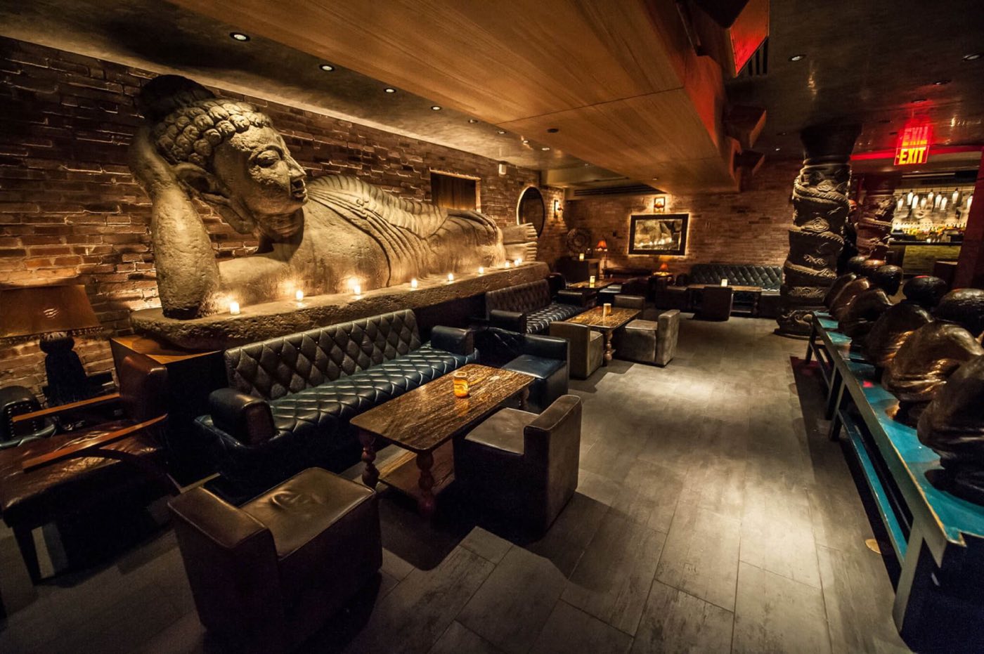 Reclining Buddha lounge with leather banquettes, low tables and a carved stone Buddha