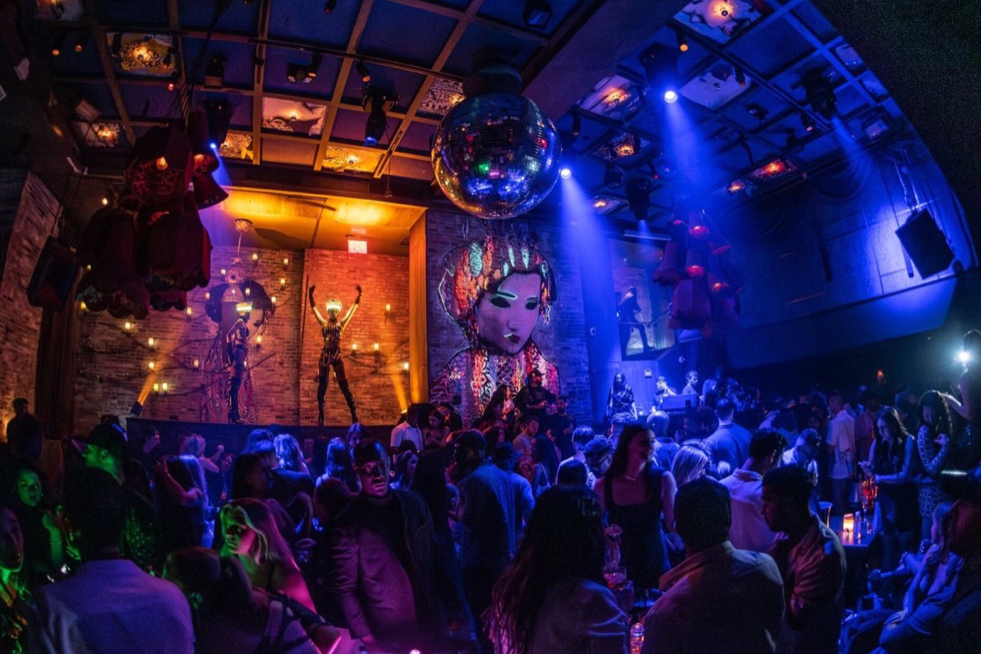 Nightclub room during an event with a crowd, stage lighting and performers