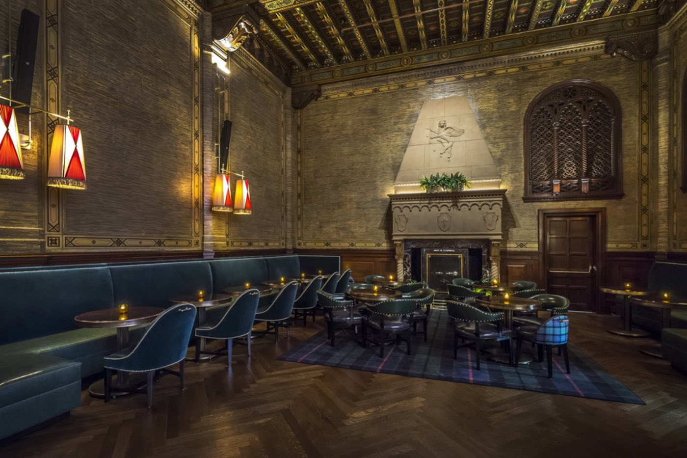 Lounge seating and banquettes in front of the carved stone fireplace