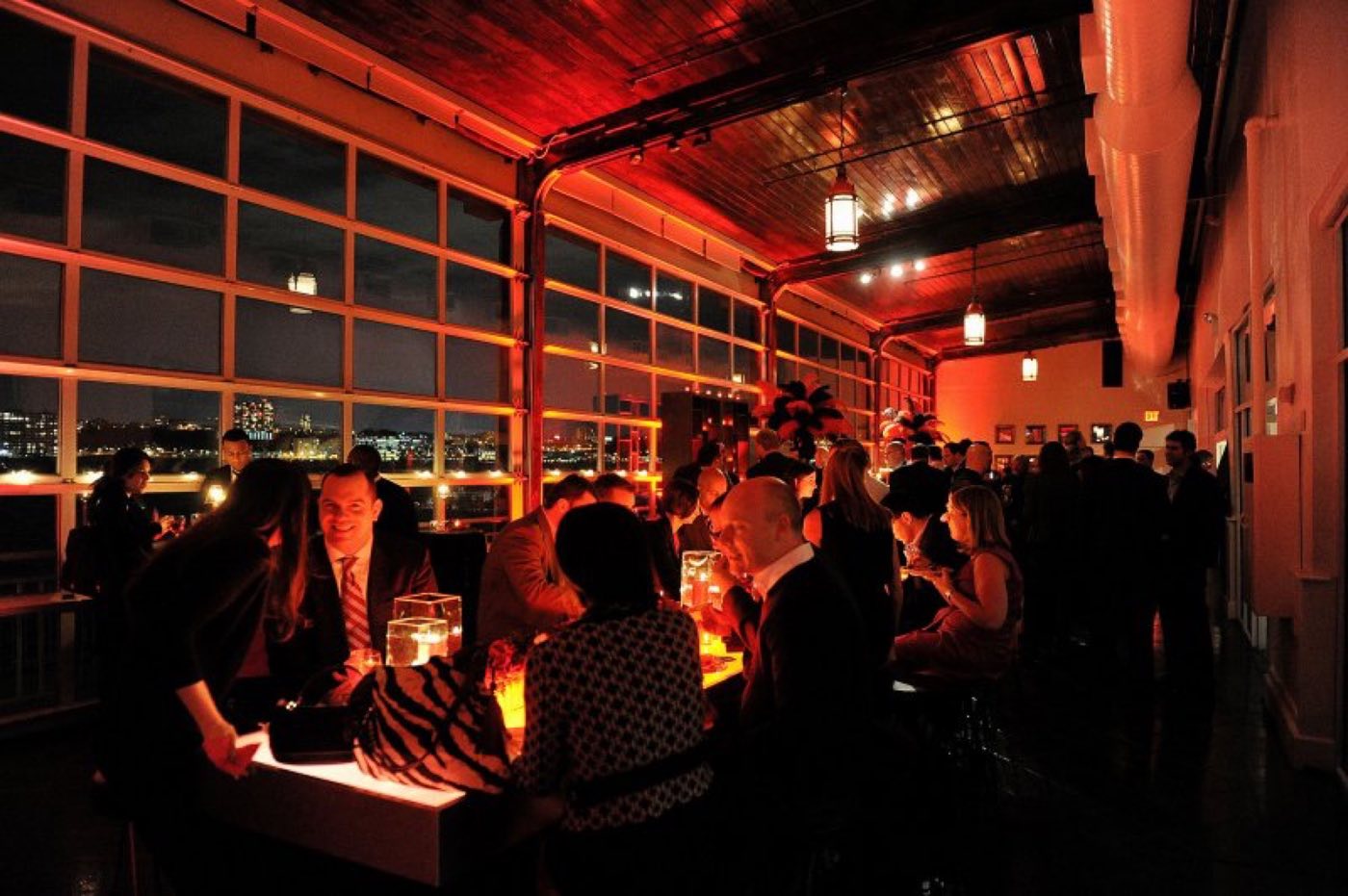 Lounge seating and warm lighting along the glass wall at night