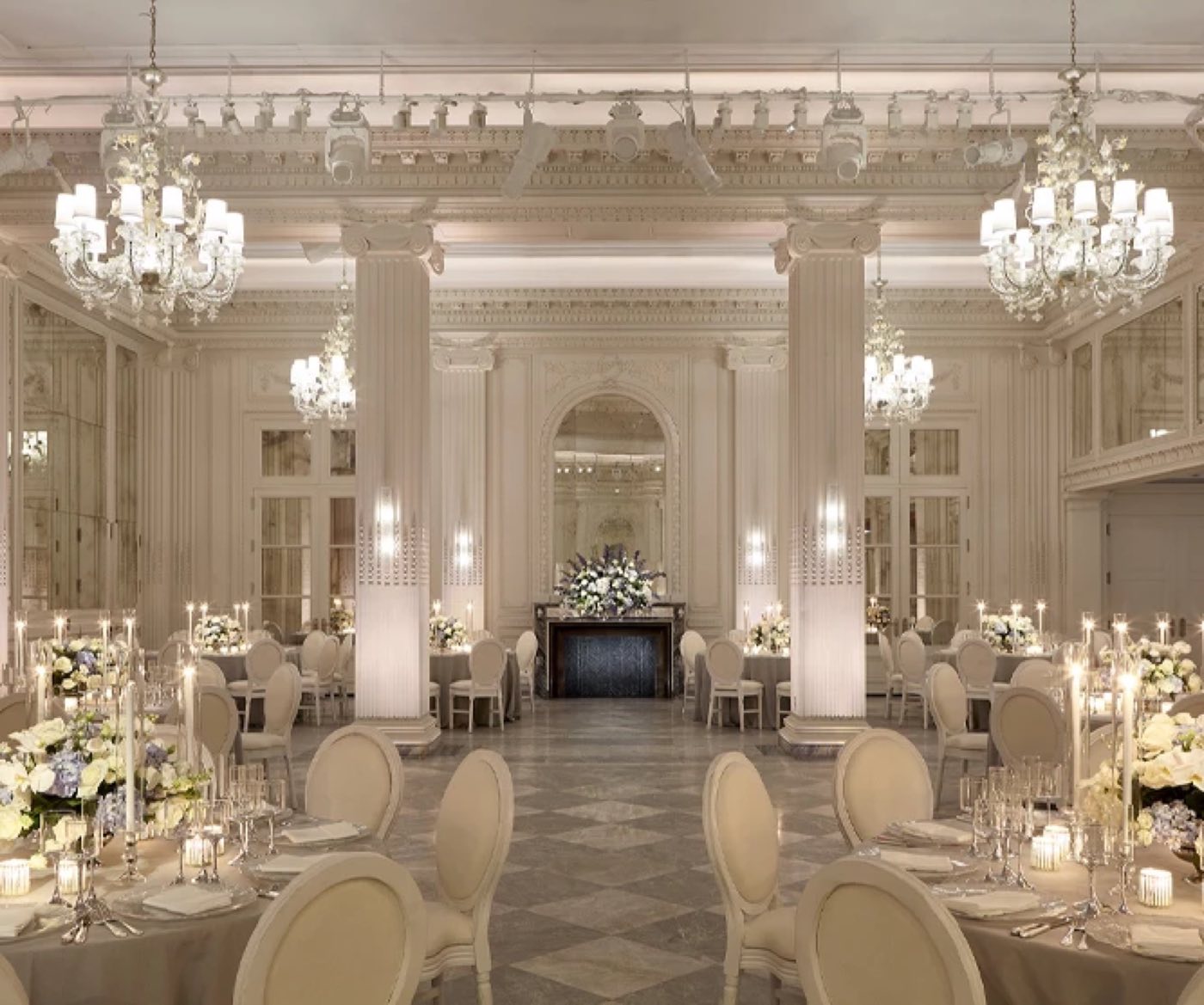 Ballroom with crystal chandeliers set for a seated dinner with round tables