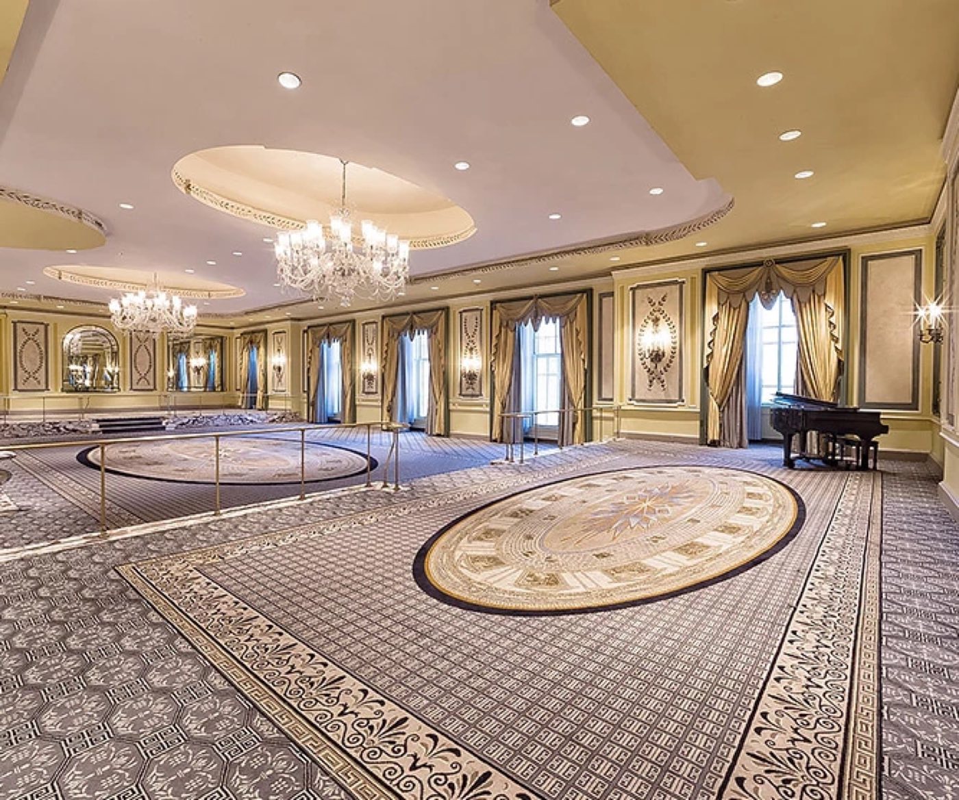 Empty Cotillion Room with patterned carpet, chandelier and wall panels