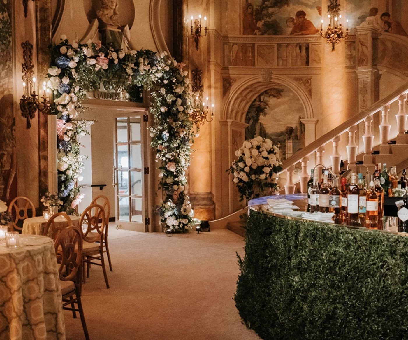Painted rotunda entrance with a staircase, floral arch and bar