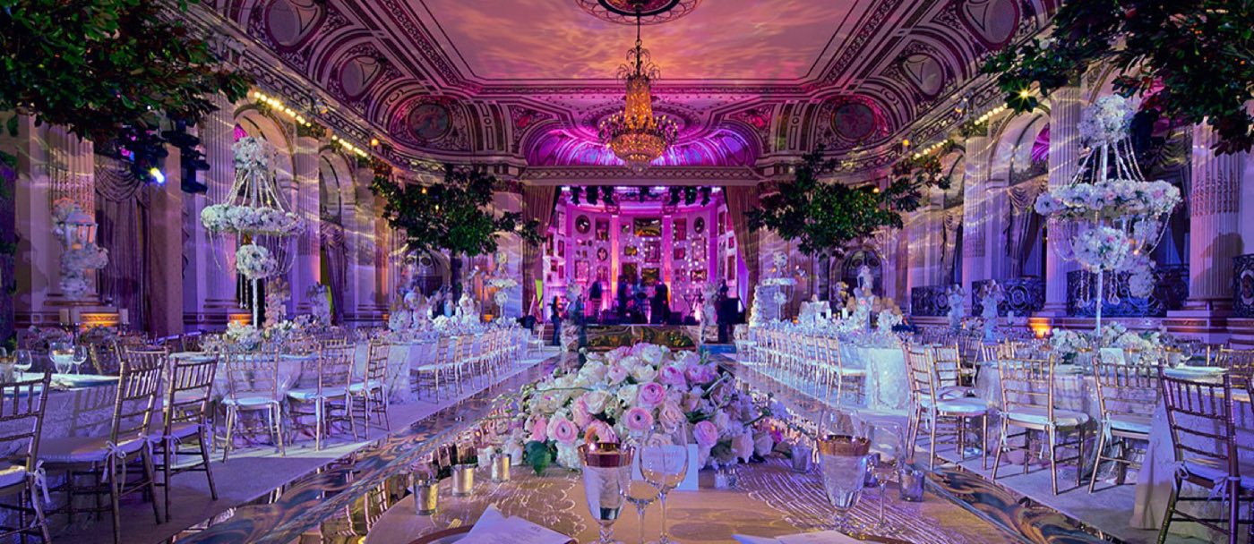 Grand Ballroom dressed for a dinner with long tables, trees and a stage