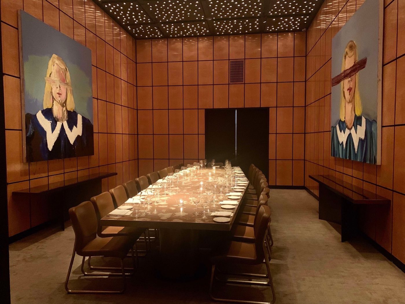 Private dining room with a long table, wood panels and large portraits