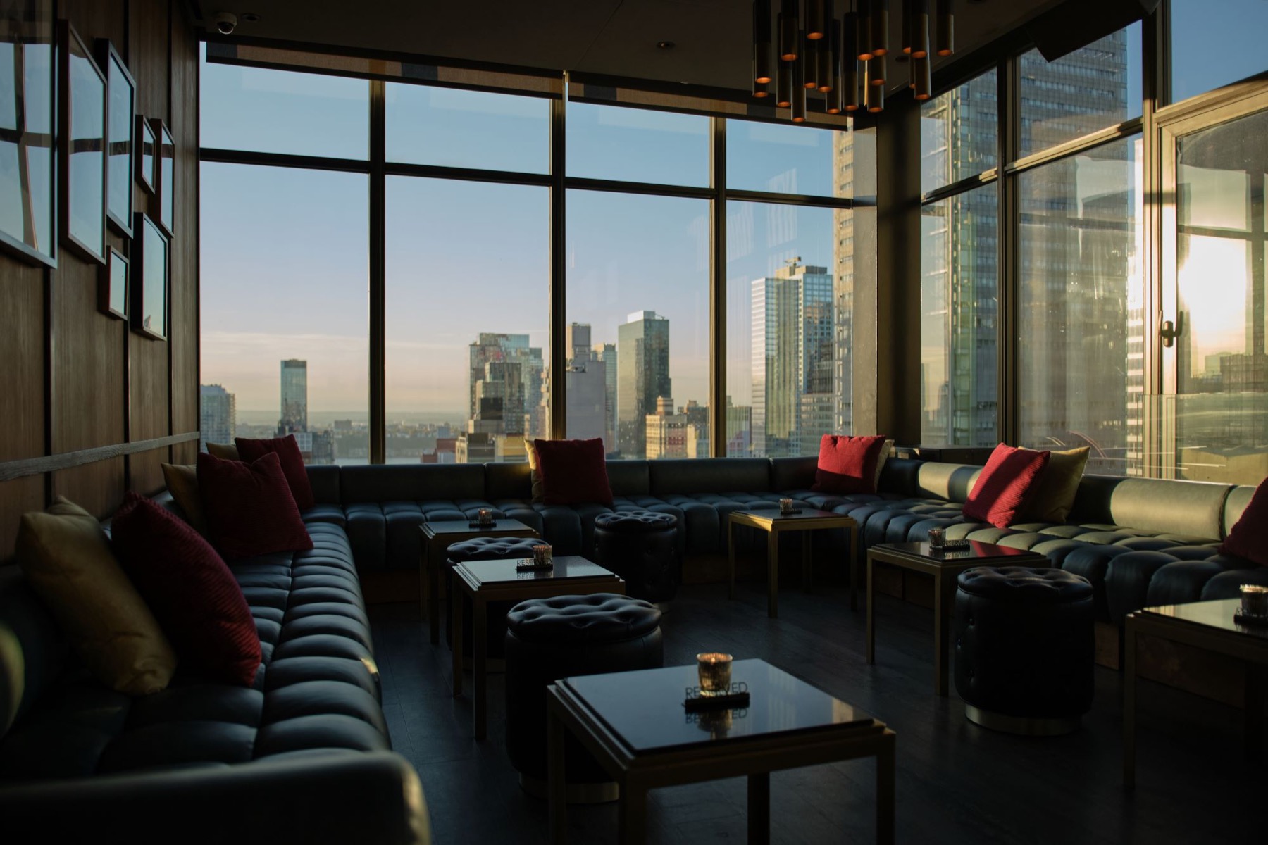 Dark lounge seating along floor to ceiling windows with Midtown towers outside