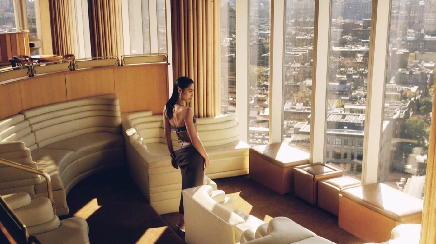 Top-floor lounge with curved cream banquettes and tall windows over the city