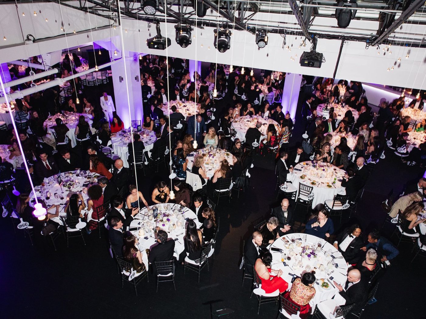 Overhead view of a seated gala dinner under a lighting truss