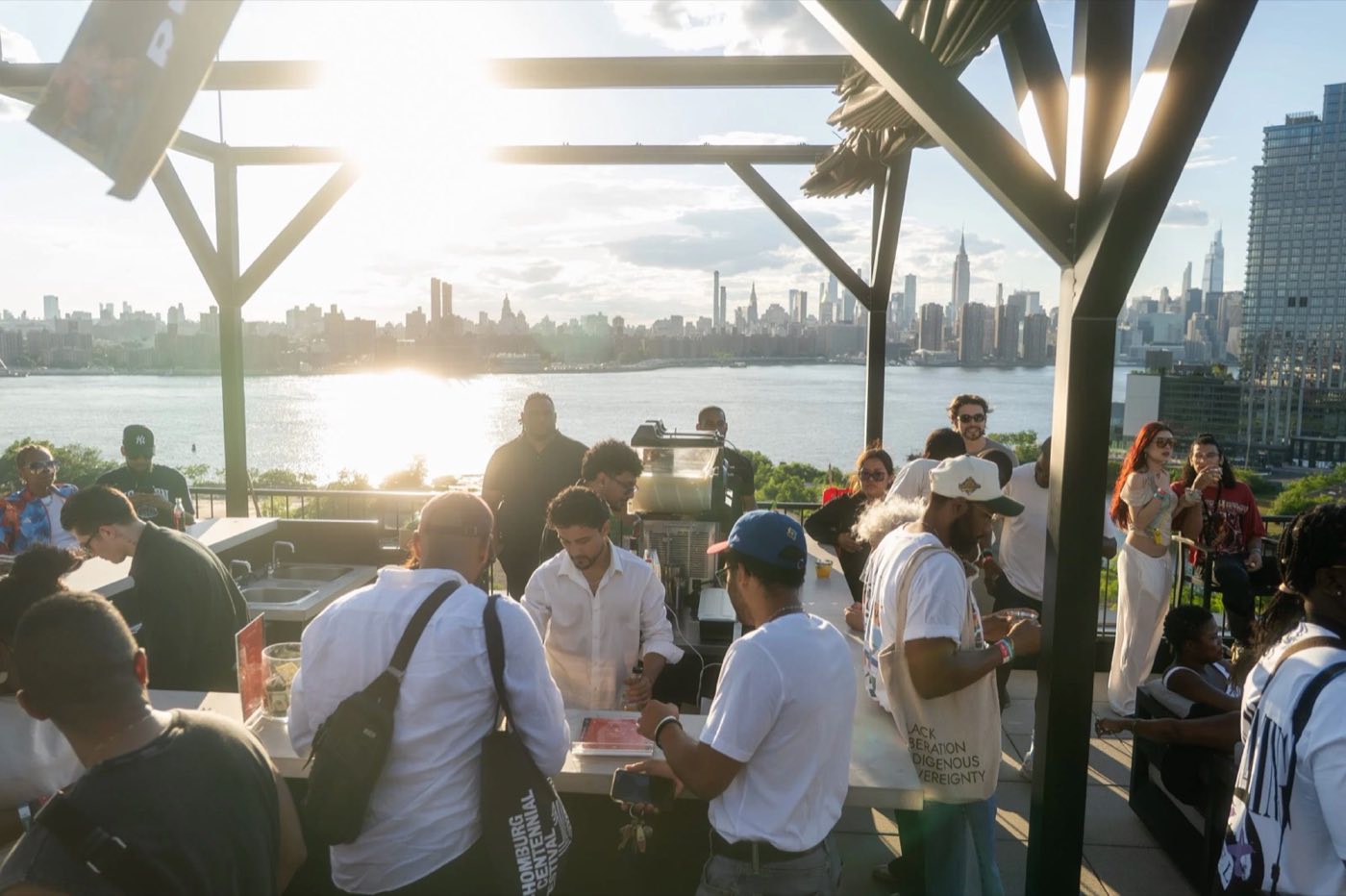 Rooftop reception at sunset with guests and the Manhattan skyline