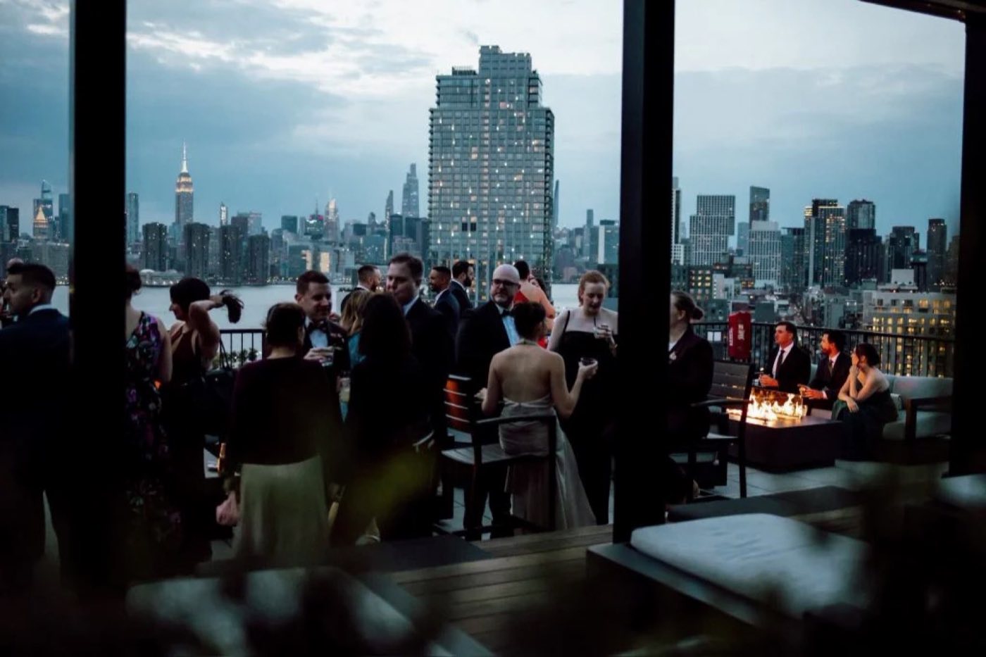 Guests mingling by the windows with the Manhattan skyline behind