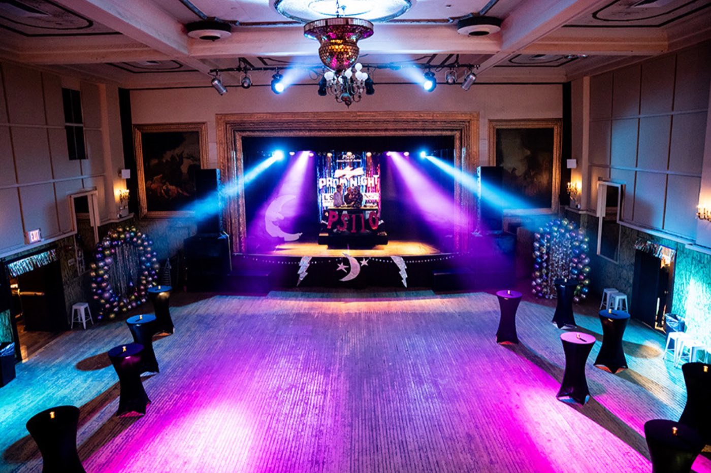 Music hall set for a gala with stage lighting and cocktail tables