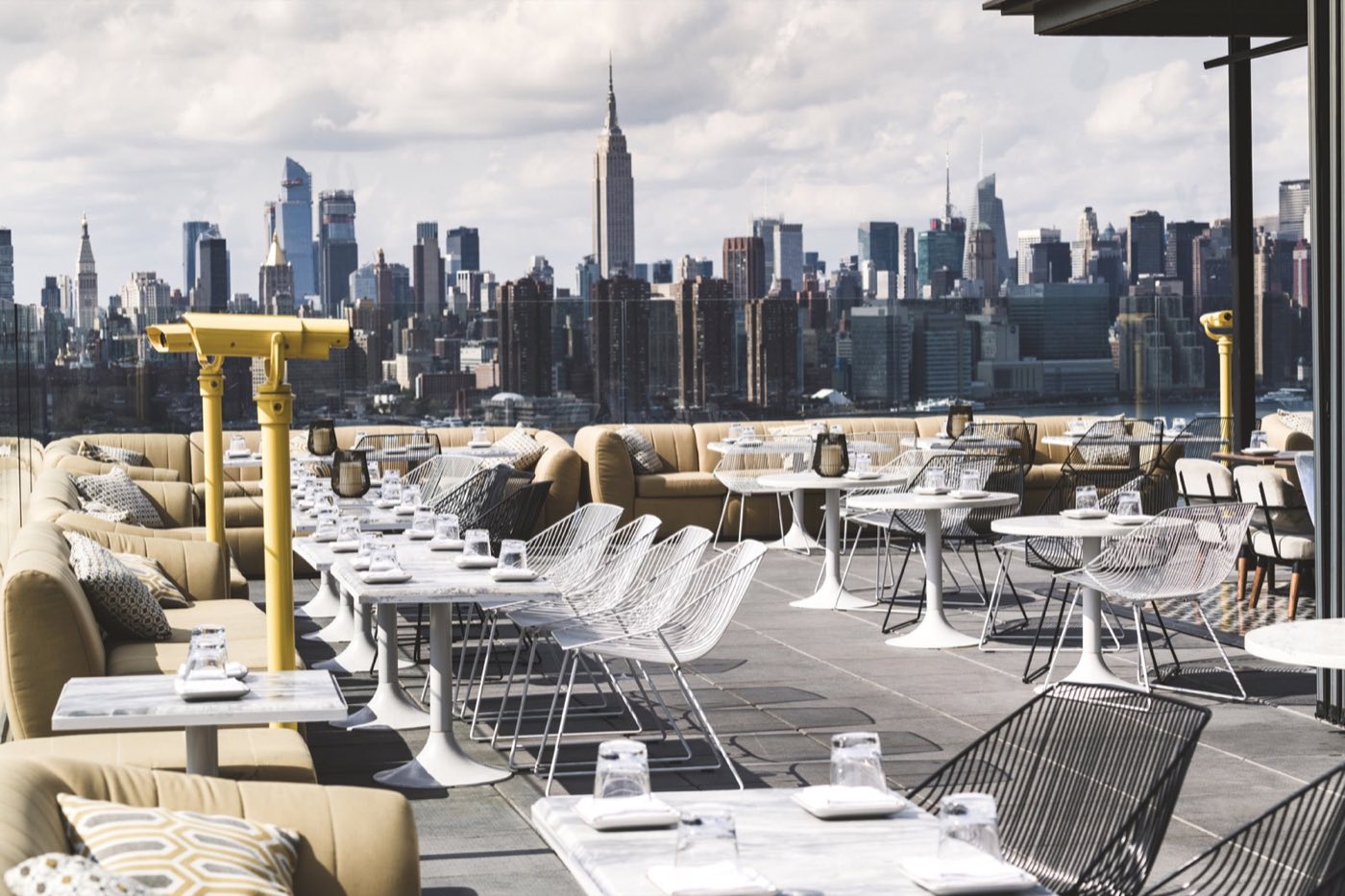 Wraparound outdoor terrace with lounge seating and a skyline view toward Midtown