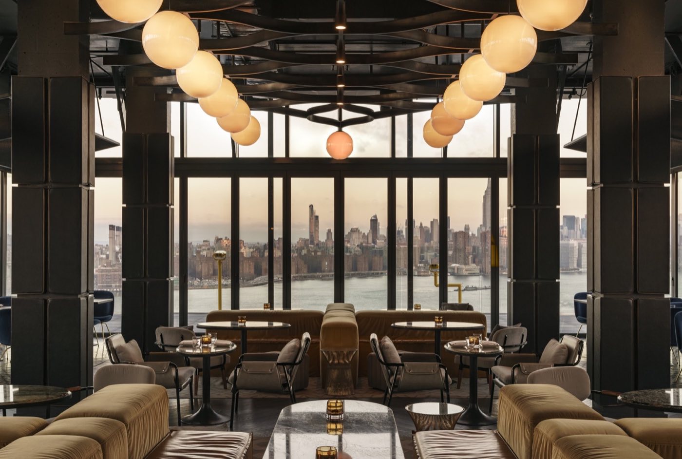 Dining area with river and skyline views through full-height glass windows