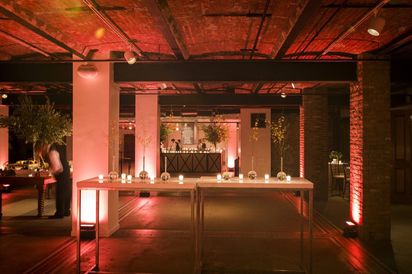 Lower-level gallery space set with lounge furniture and warm uplighting
