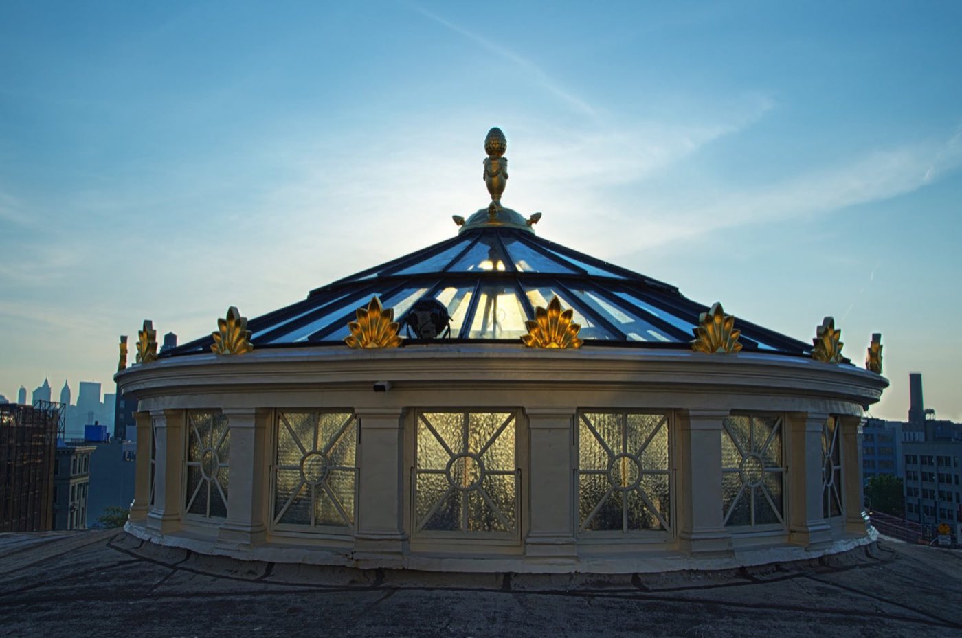 Glass oculus dome on the roof with the city skyline behind