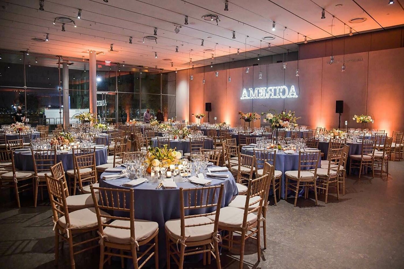 Griffin Hall set with round dinner tables under warm light and tall windows