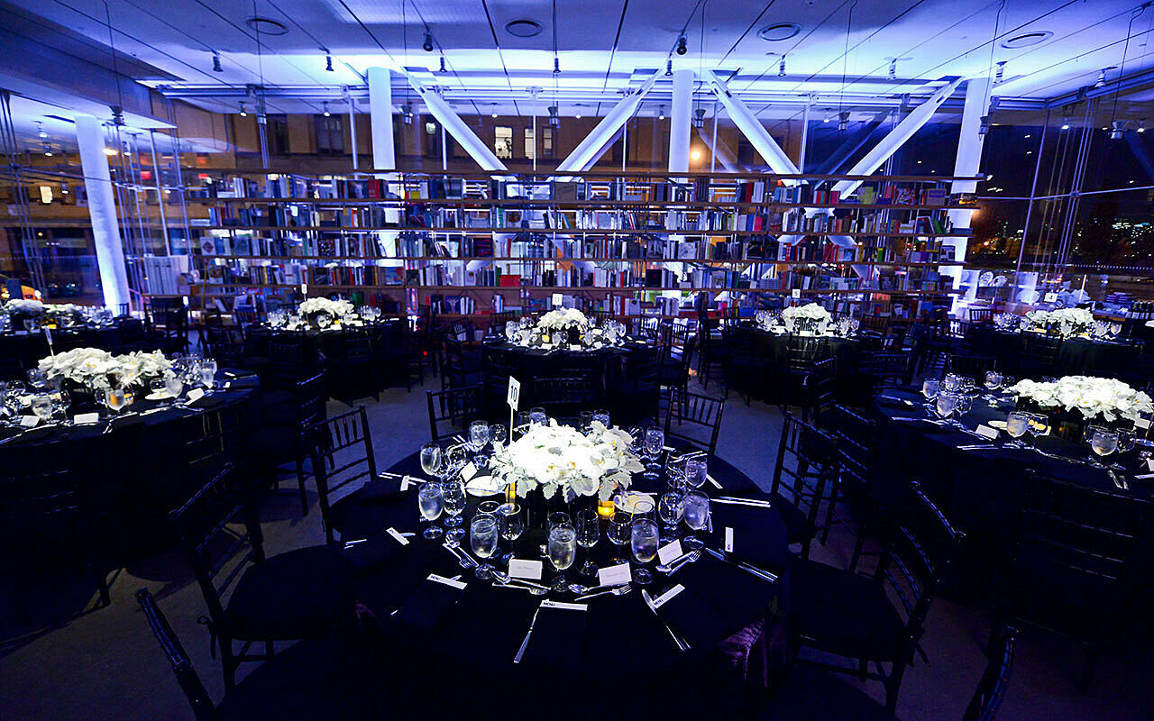 Lobby hall with round tables and white flowers under cool blue lighting