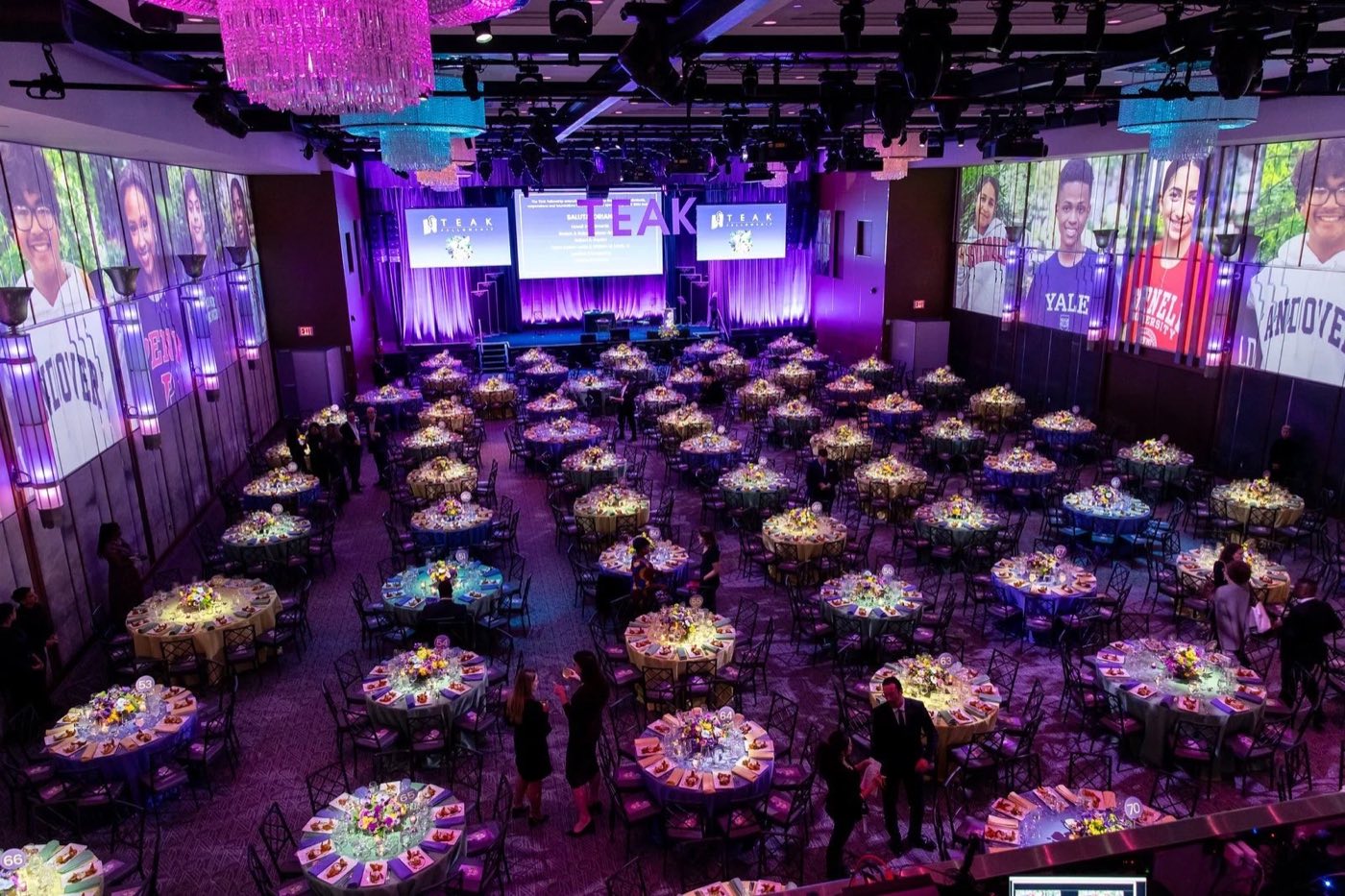 Overhead view of the ballroom set with round tables and projection on the walls