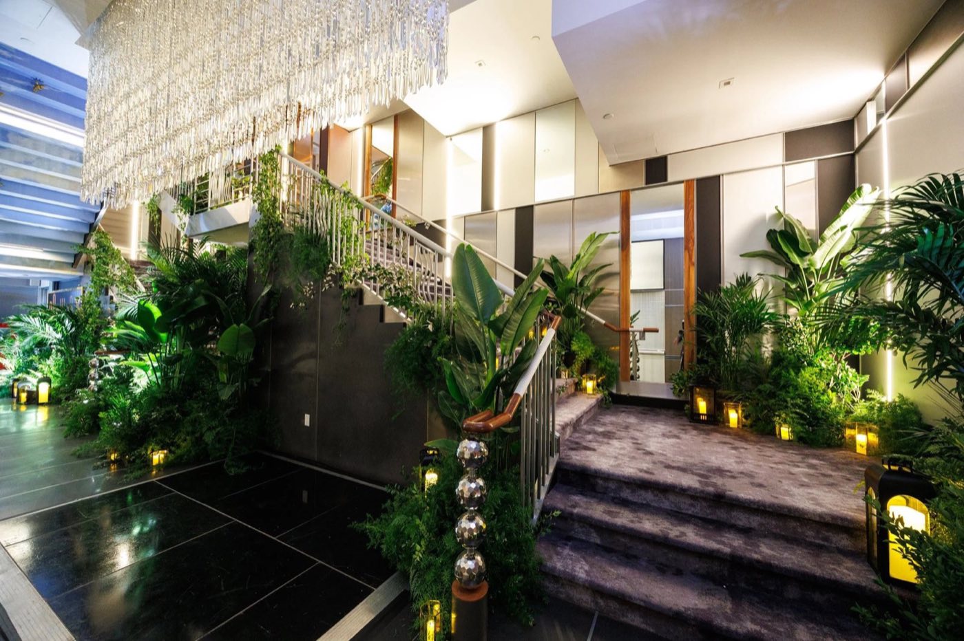 Lobby staircase and foyer decorated with greenery and uplighting